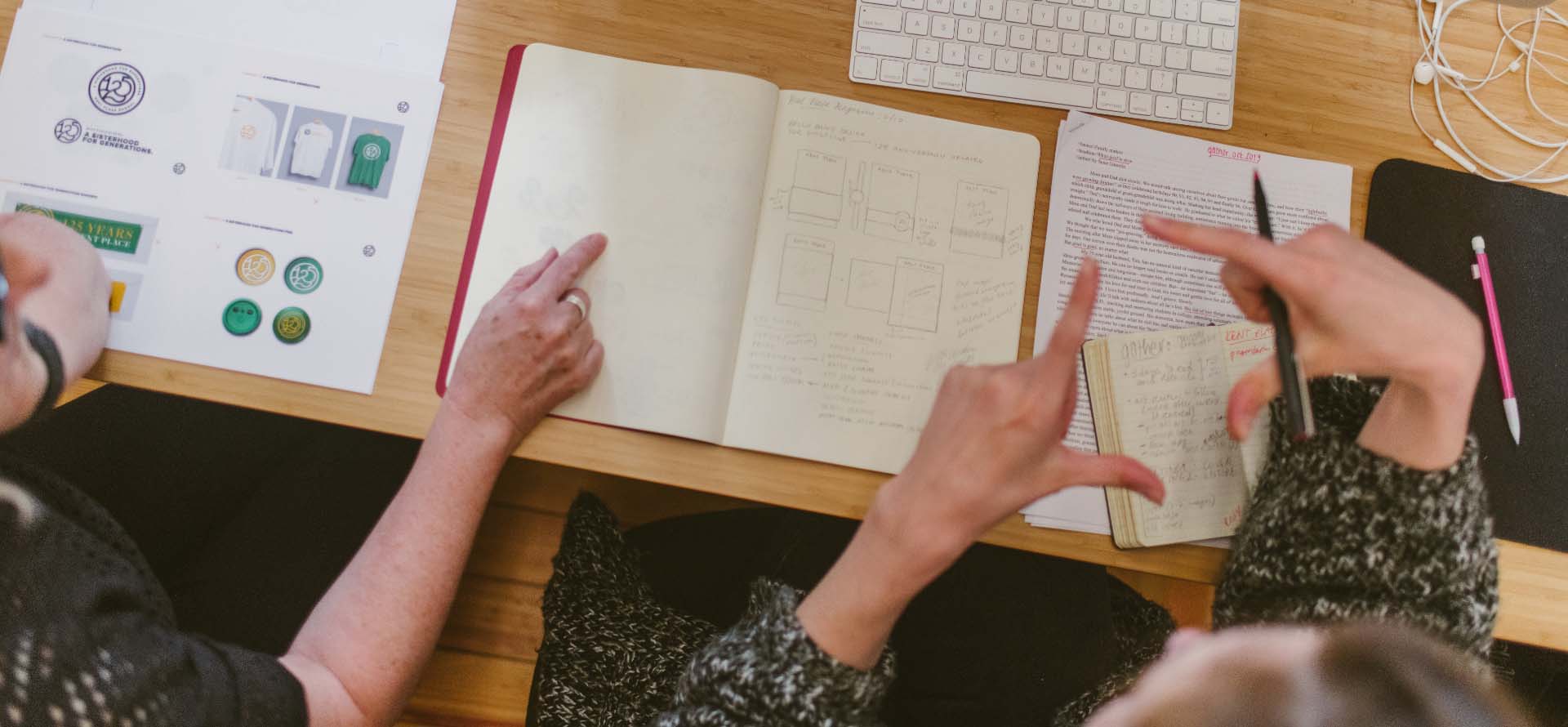Designers sitting at desk discussing a sketch
